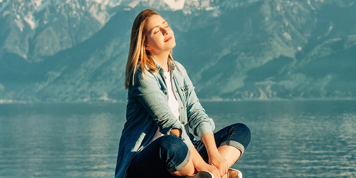 woman meditating on a lake