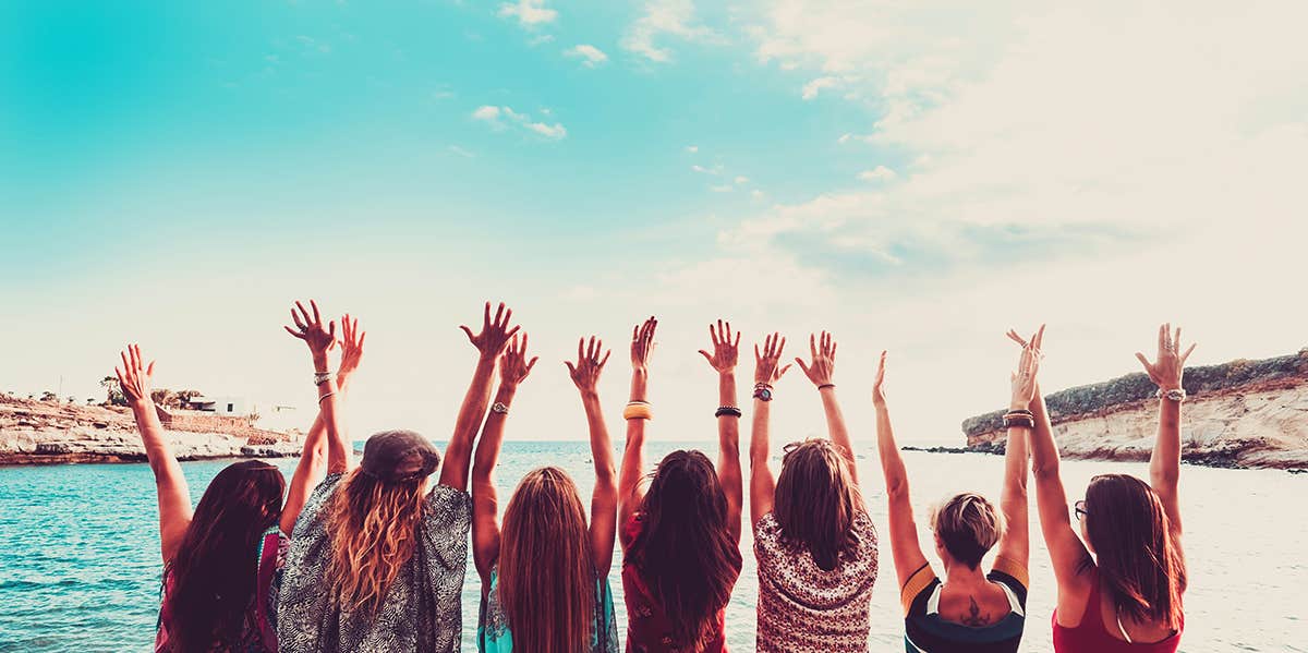 group of friends with hands in the air