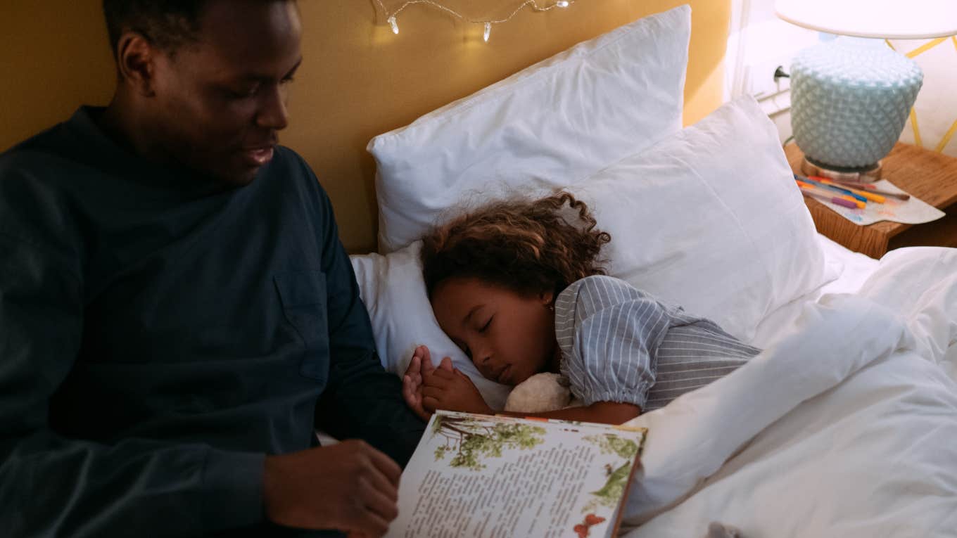 dad reading to daughter in bed