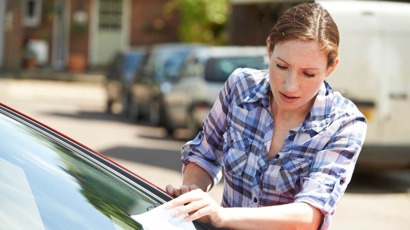 woman getting a parking ticket while doordashing