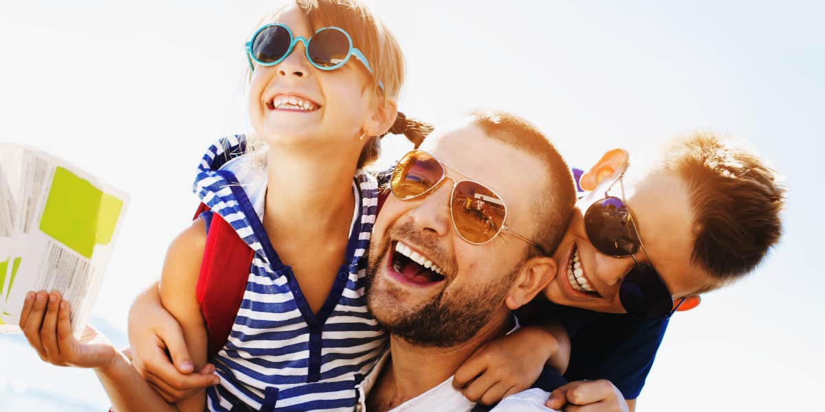 two kids play outdoors with their dad 