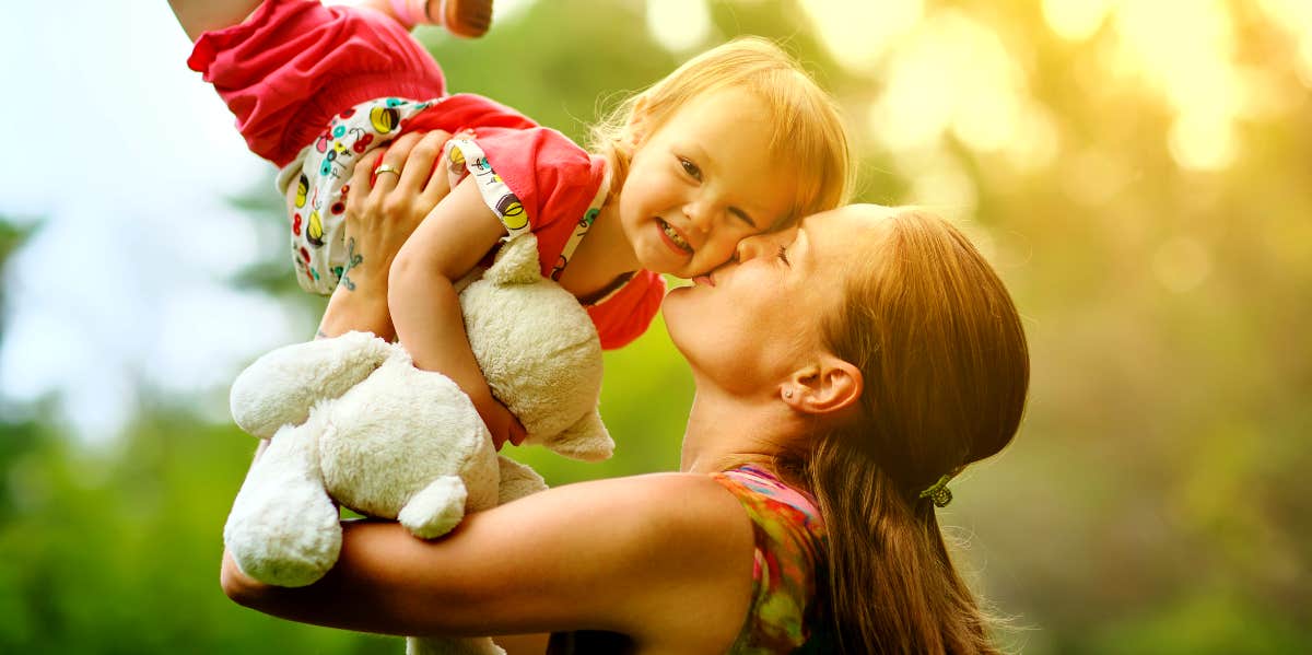 Mom gives toddler a kiss on the cheek