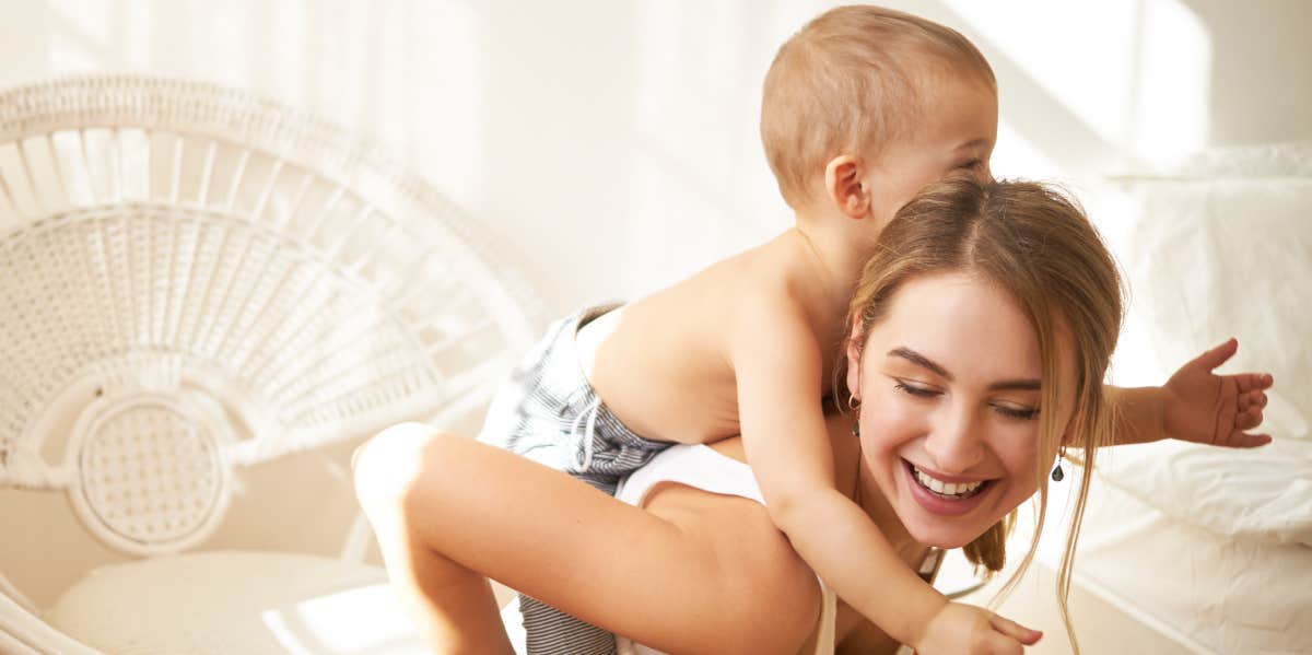 teenage girl babysitting little boy and giving him a piggyback ride