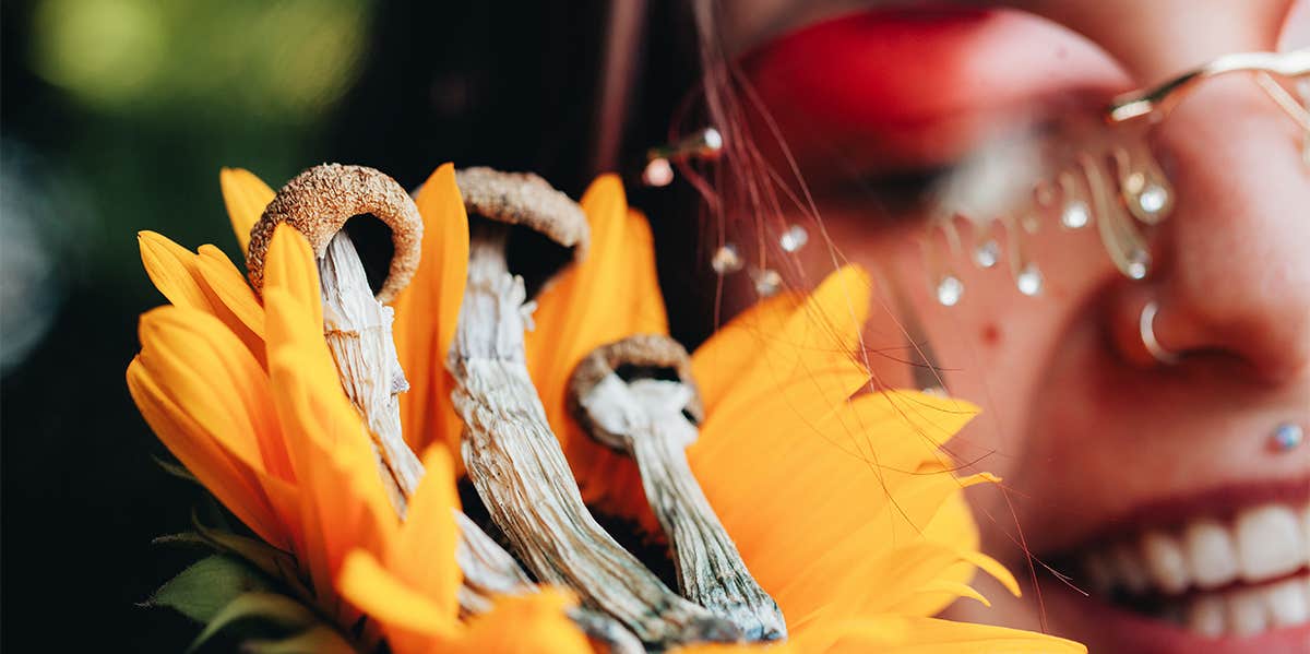 smiling girl next to sunflower and mushrooms