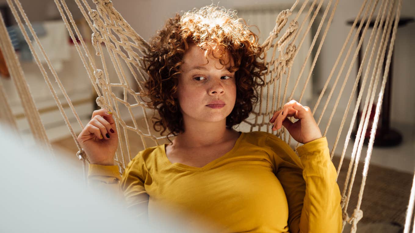 Woman looking solemn in a hammock. 