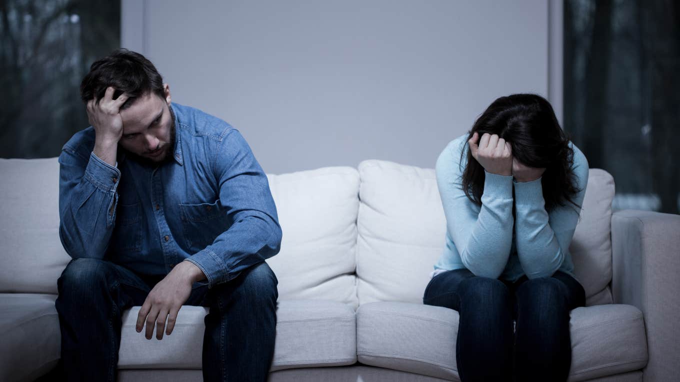 upset couple sitting on opposite sides of a couch