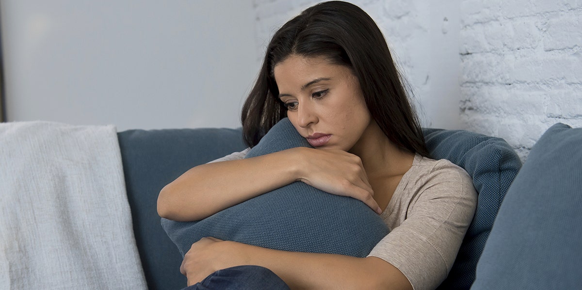 My Therapist Slut-Shamed Me woman looking sad, holding couch pillow