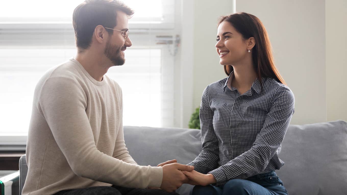 couple holding hands on the couch