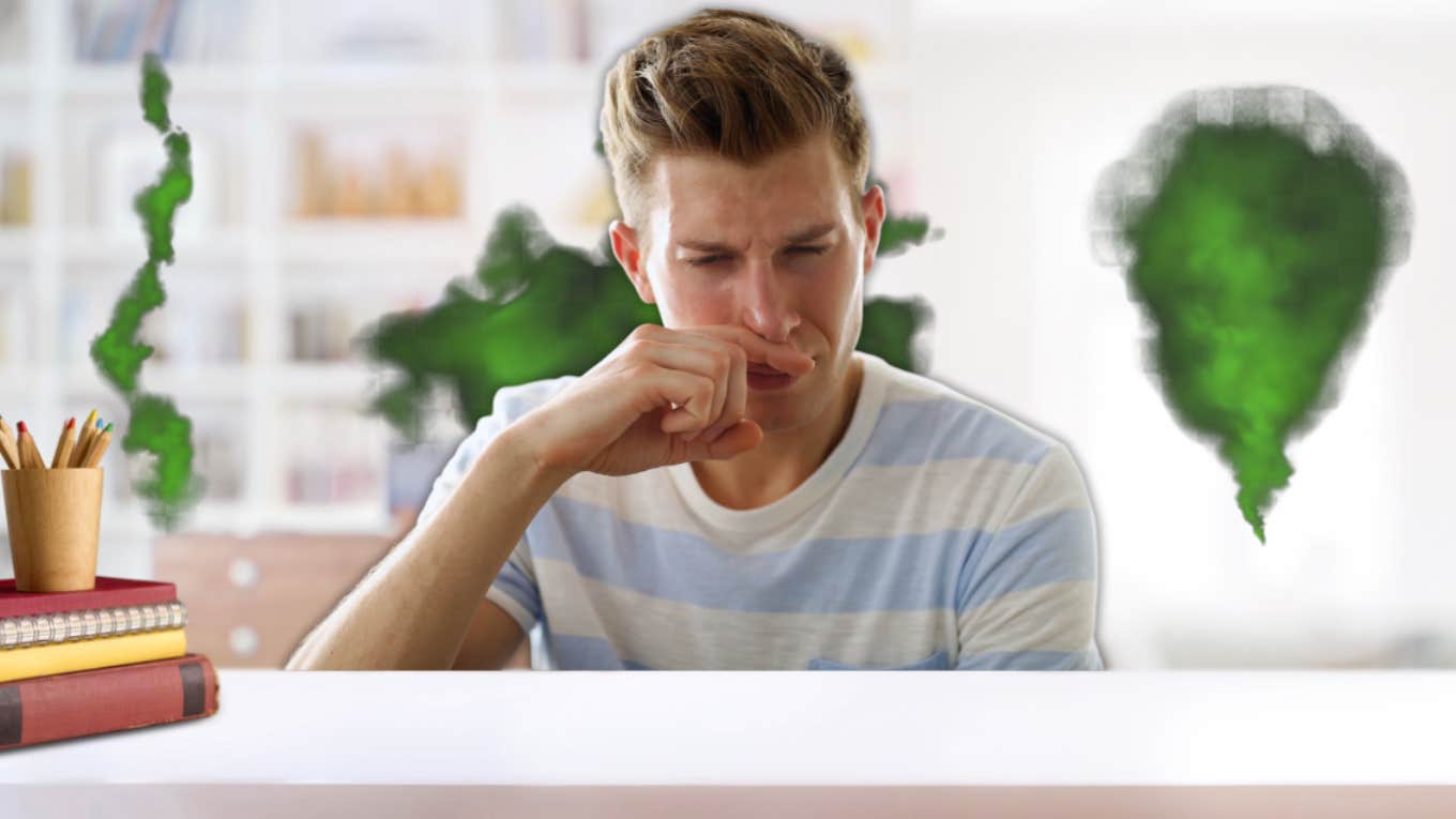 Man covering his nose due to stinky classroom