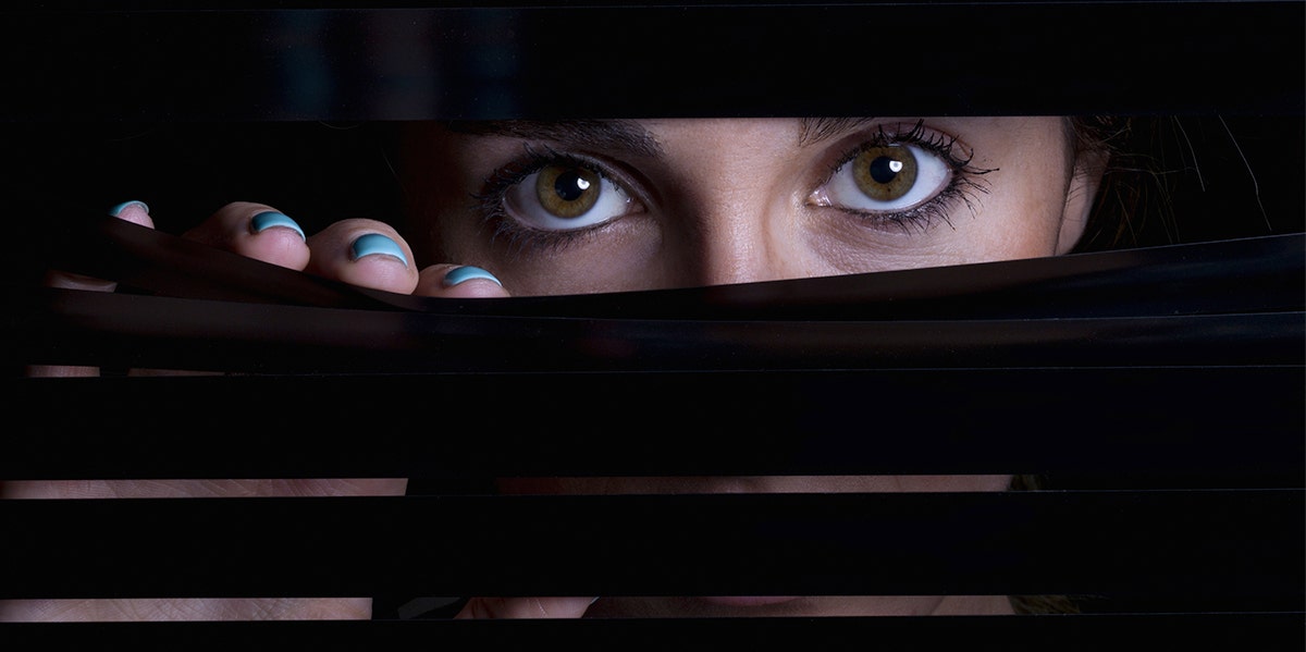 woman peeking from behind blinders