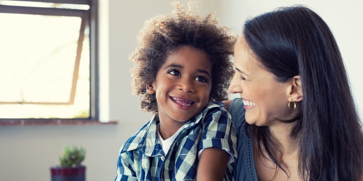 smiling mom and child in front of window