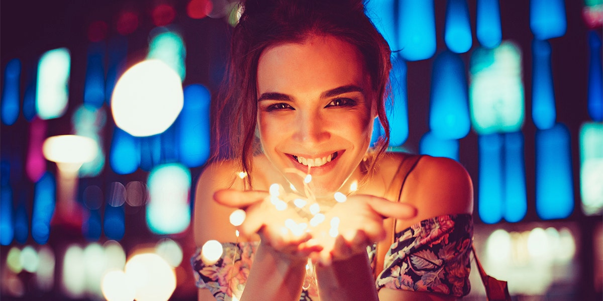 How An Astrology Reading Saved Me From A Toxic Relationship woman holding lights