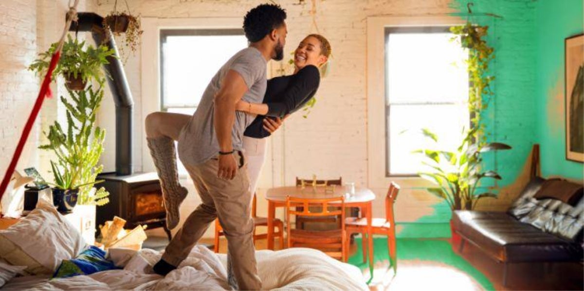 couple smiling holding each other dancing around