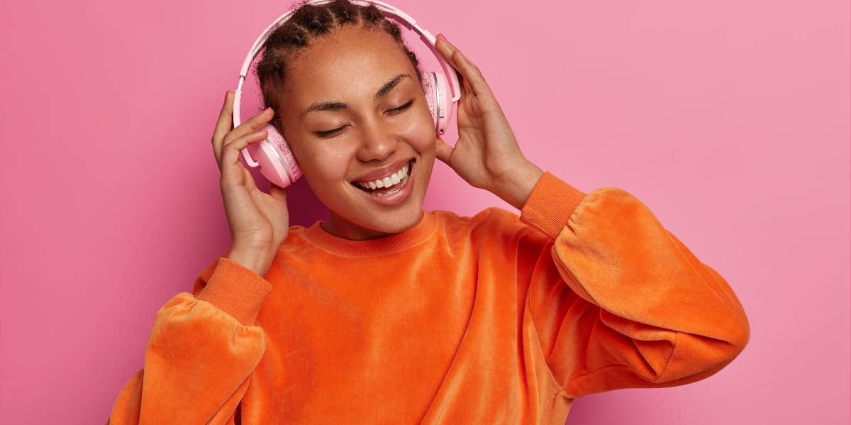 young woman with headphones on listening to songs about life