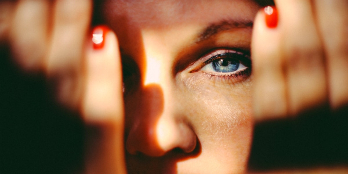 blue eyed woman hands over eyes