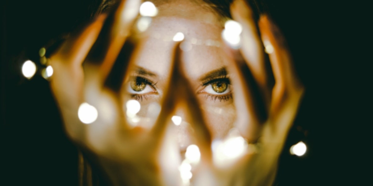 woman with lights tangled in fingers