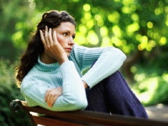 Woman on bench looking forlornly