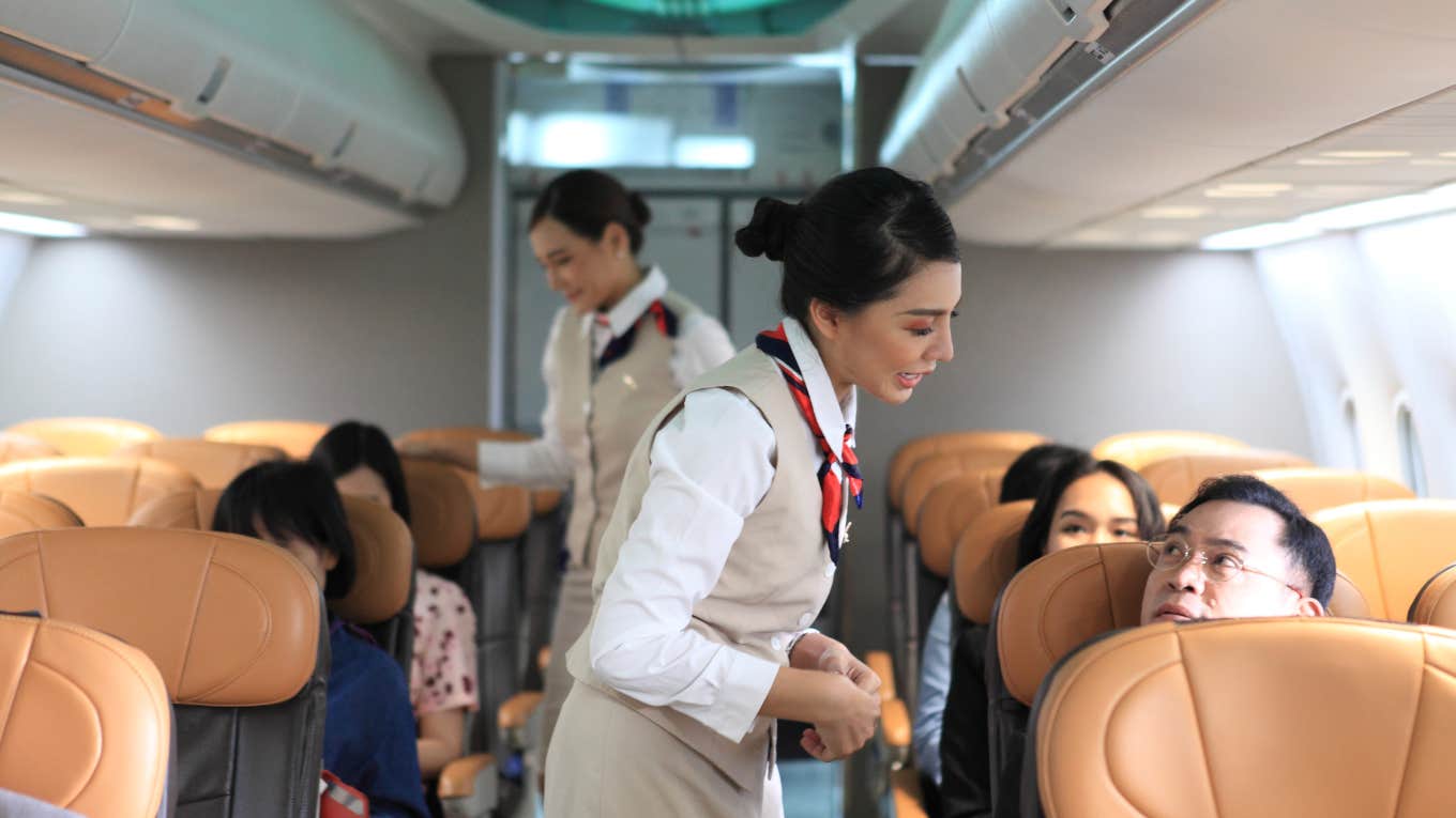 flight attendant talking with plane passengers