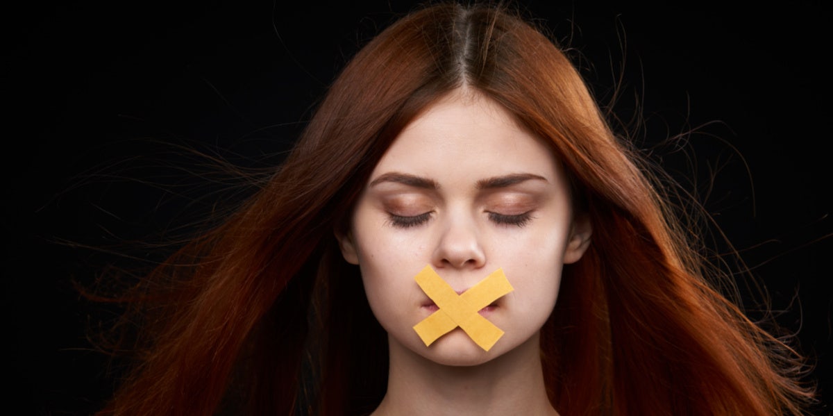 woman with x taped over her mouth