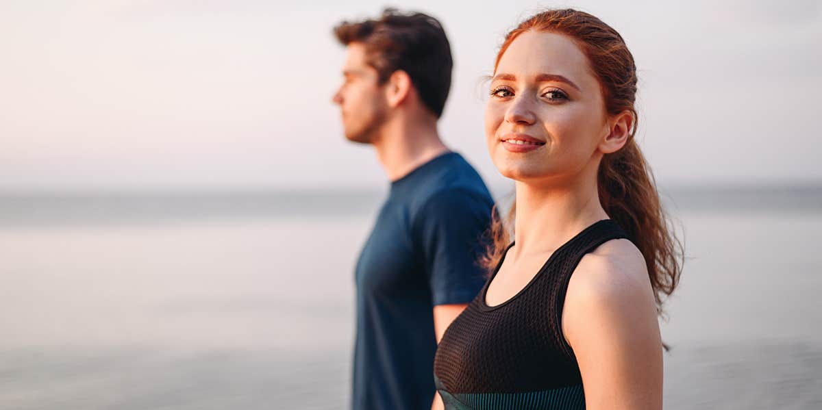 woman walking on beach next to man