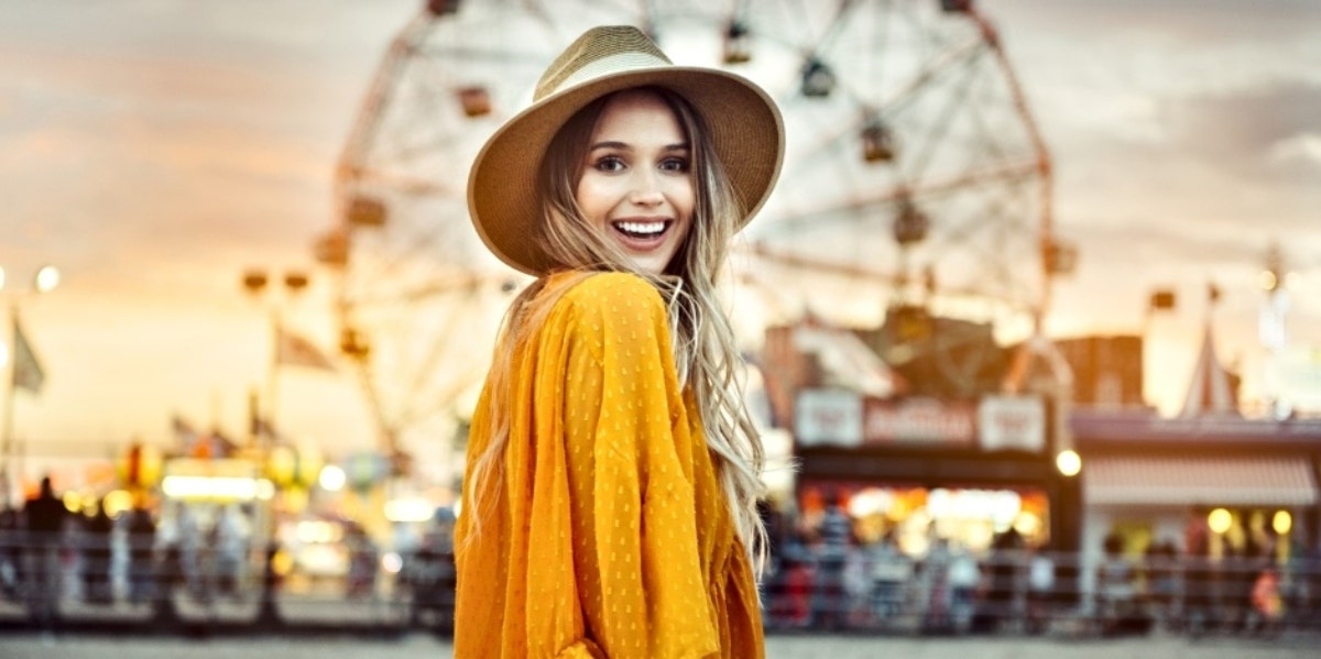 girl smiling in front of ferris wheel