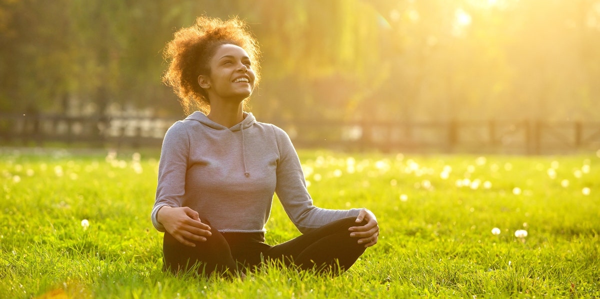 woman sitting on the grass under the sun