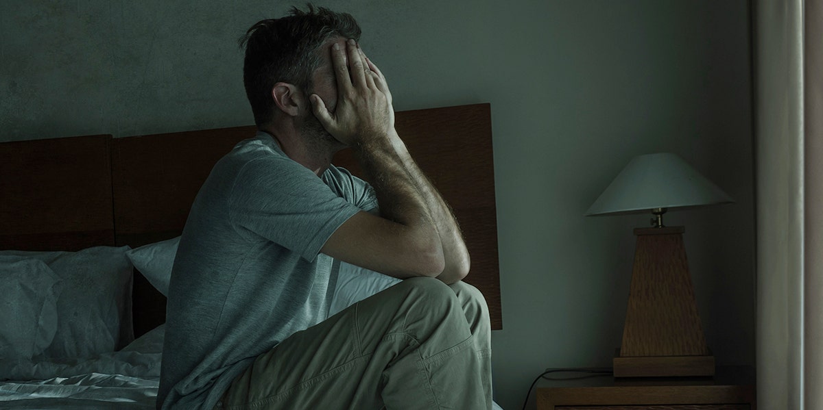 What It's Really Like To Be The Spouse Of A Sex Abuse Victim man with head in hands sitting in dark