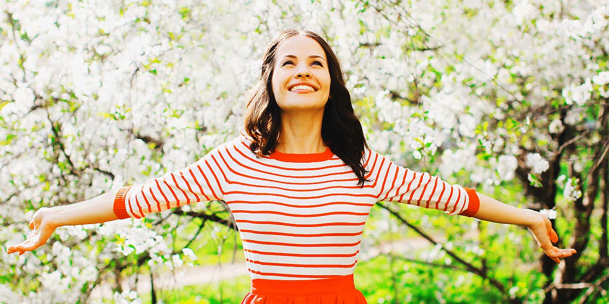 brunette woman smiles in spring blossoms