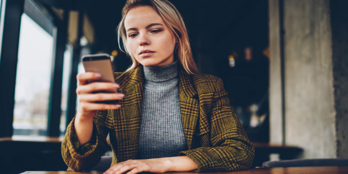 sad woman looking at phone