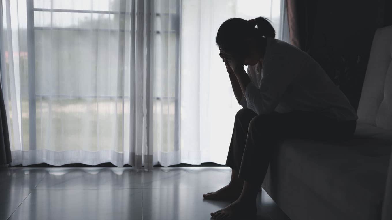 Stay-At-Home Mom Feels 'Shame' Over Not Having Her Own Money sad woman sitting in dark room