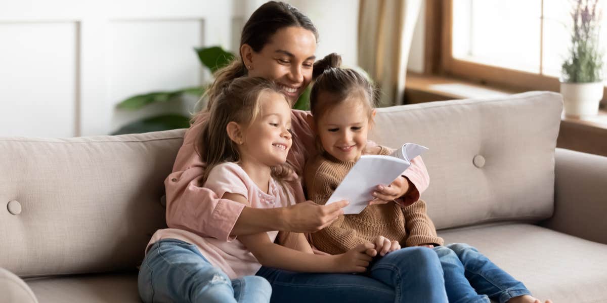 mother reading to two daughters