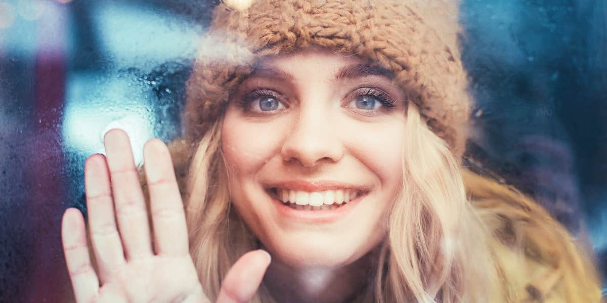 Happy woman looking through train window