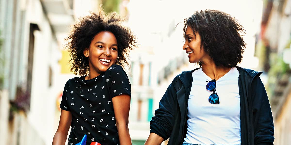 stepmom and daughter walking down a fancy street, laughing