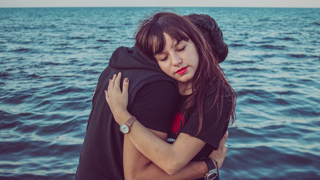 woman hugging man over the water