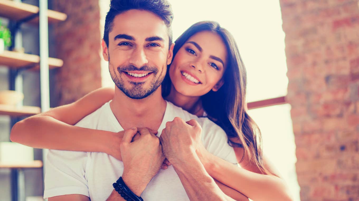 woman hugging man and smiling at the camera