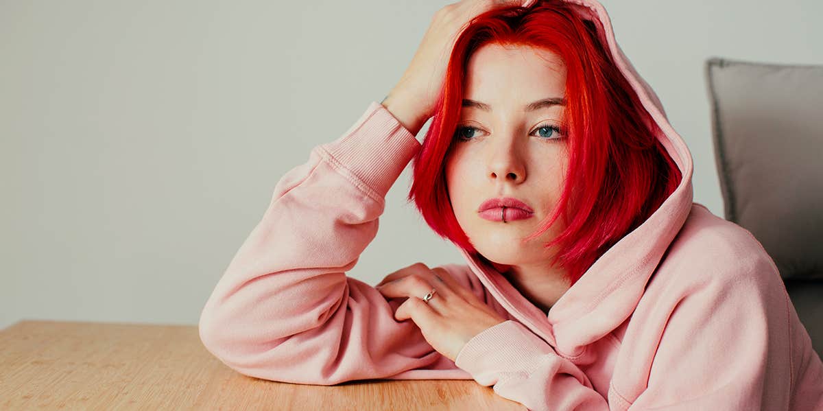 young woman stressed leaning on a table