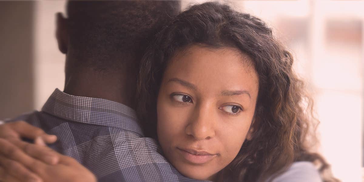 woman hugging a man, looking confused