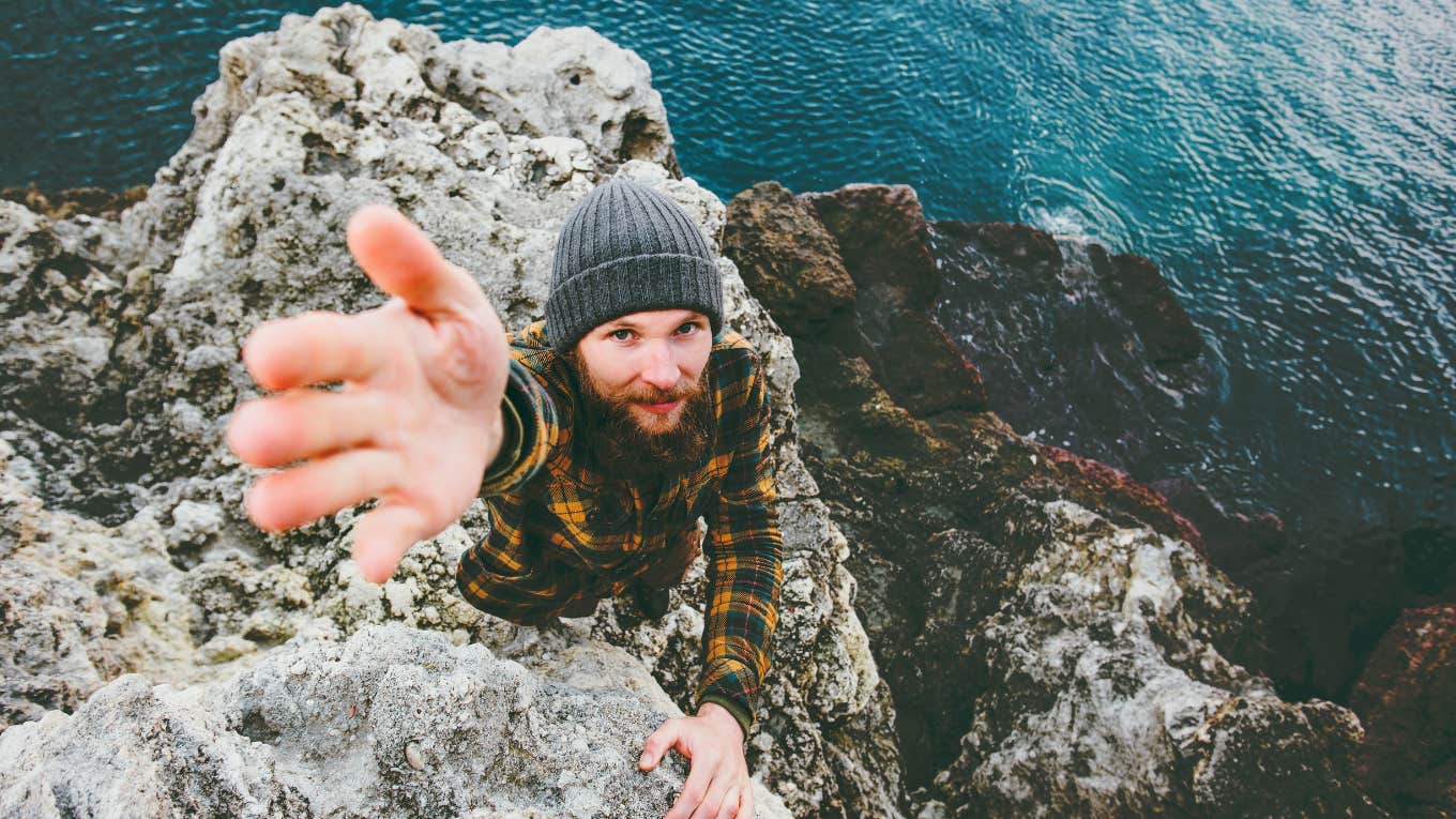 a man climbing a cliff and looking up