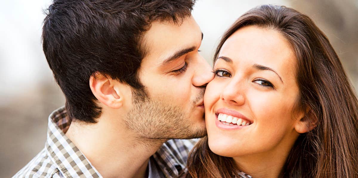 Happy couple with man kissing woman on cheek