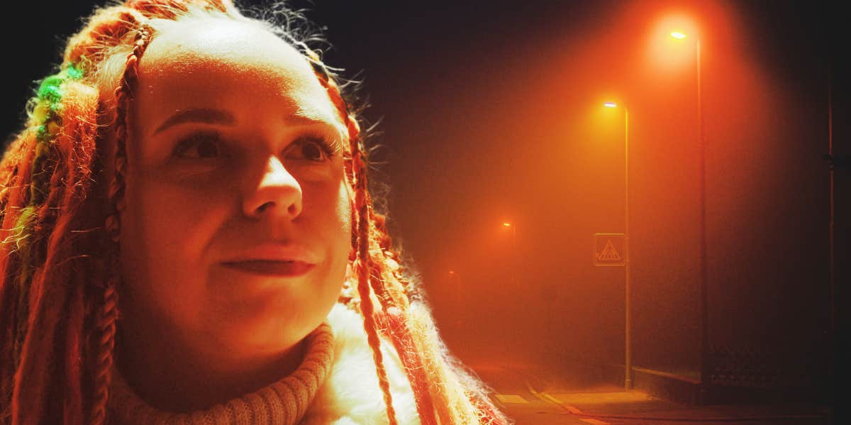 woman standing under street lights