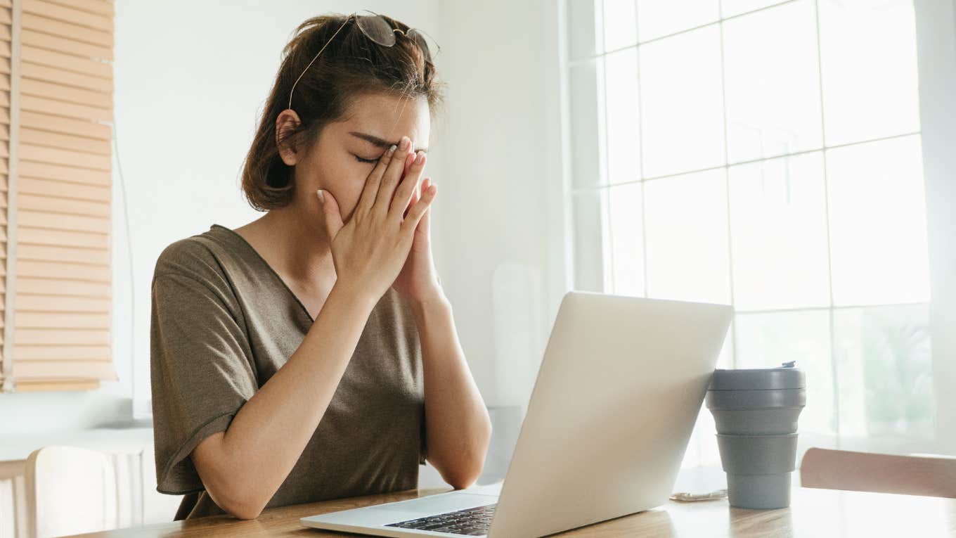 Young woman looks disappointed while looking at her laptop. 