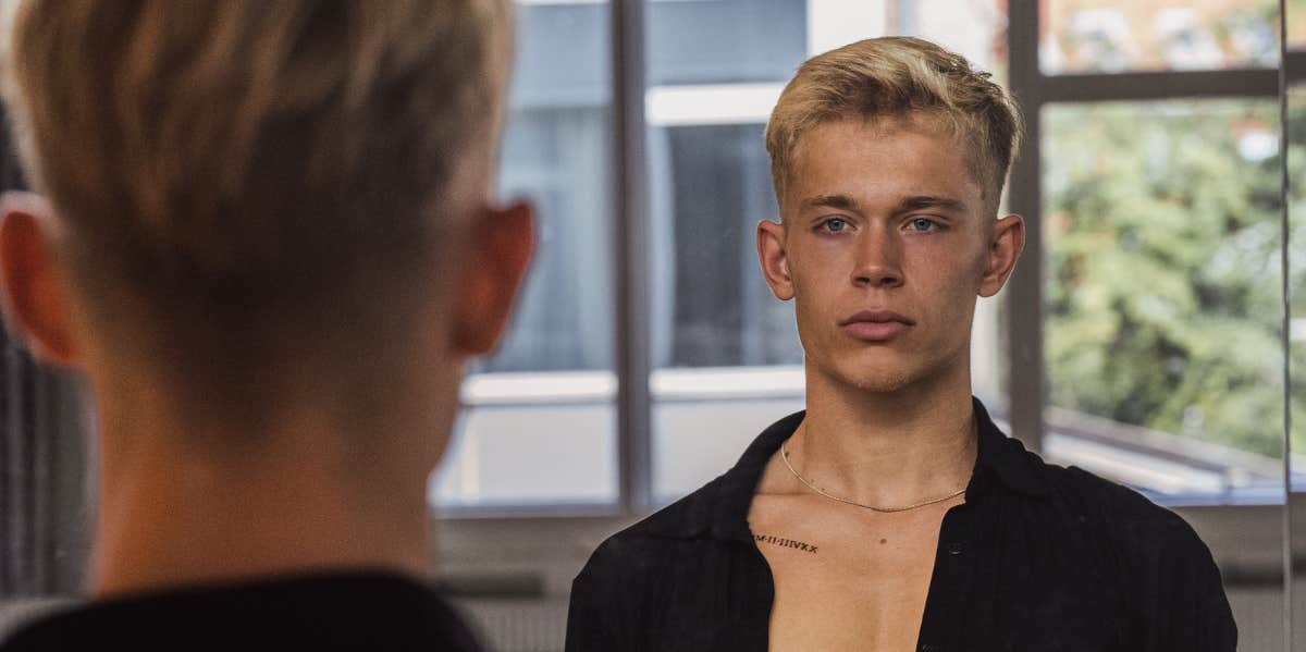 Study Reveals Women Least Attracted To Men With This Hair Color man looking in mirror