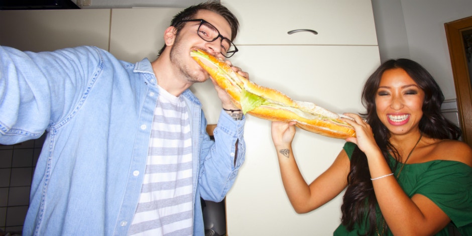 man and woman sharing a sub sandwich