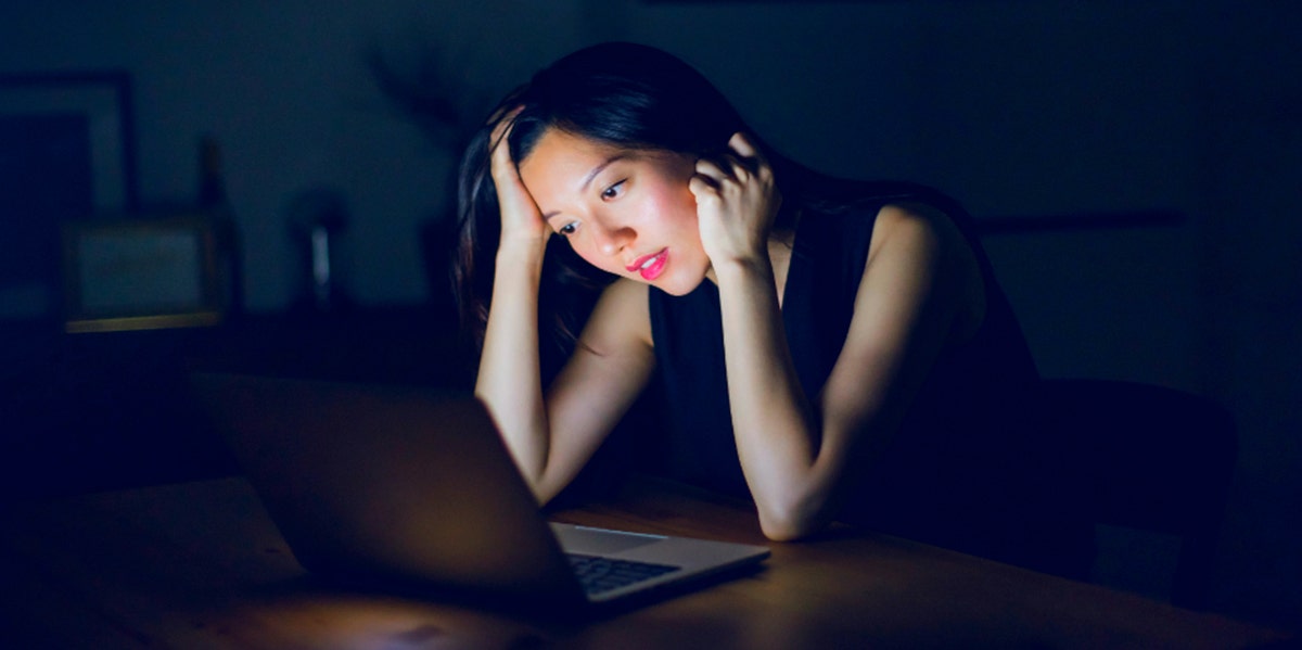 woman in black staring at a screen