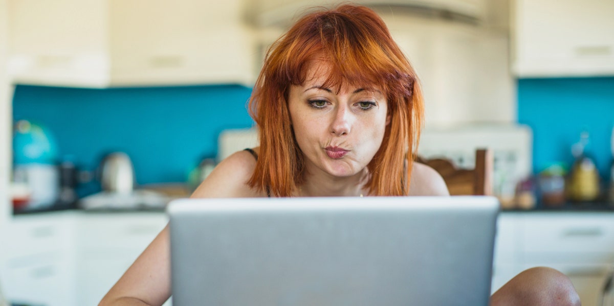 woman with red hair looking at computer screen