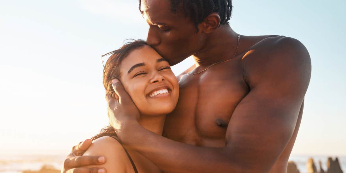 man kissing woman at the beach