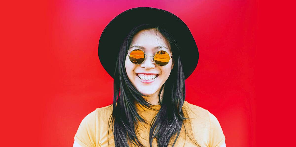 woman wearing vintage sunglasses red background