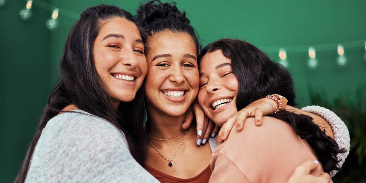 three adult sisters hugging