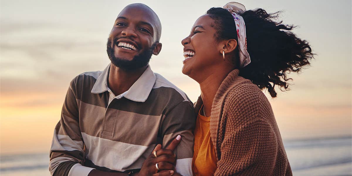 The Surprising Words That Mean Way More Than 'I Love You' laughing couple on the beach