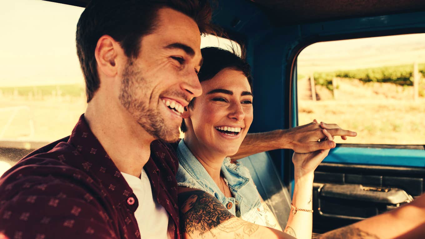 Cheerful young couple on a road trip enjoying the ride